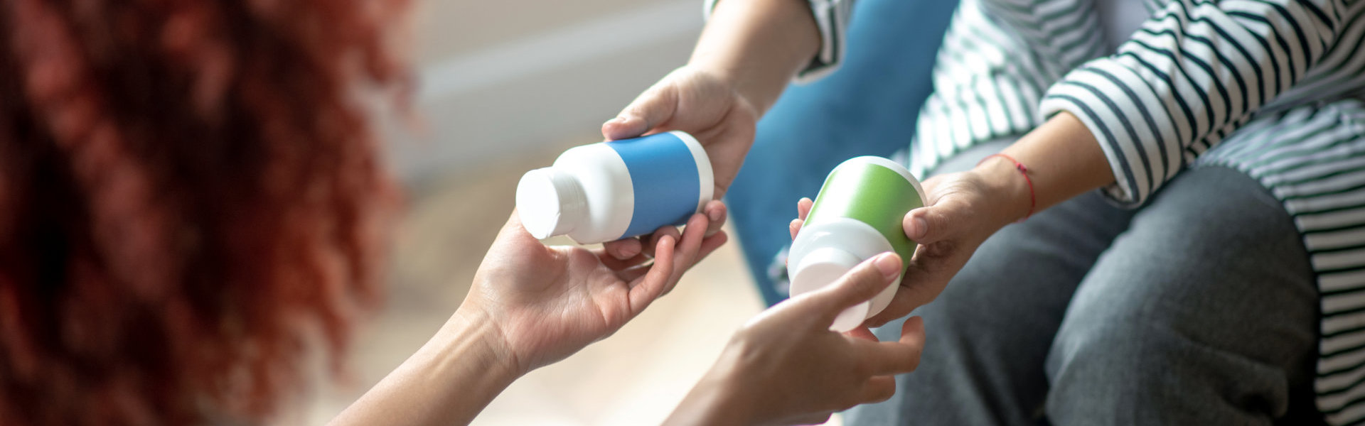 Woman giving medicine bottle to patient